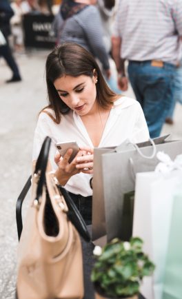 Shopping-girl-looking-her-mobile-phone.jpg